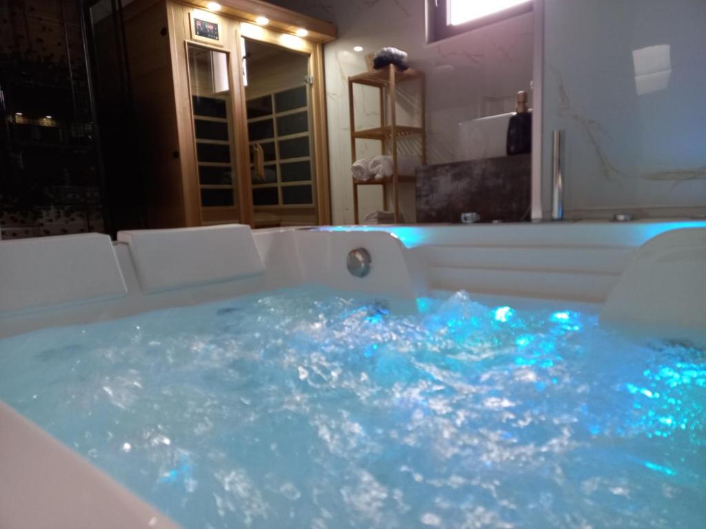 a bathroom with a tub filled with blue water at Villa Tina in Štrpce