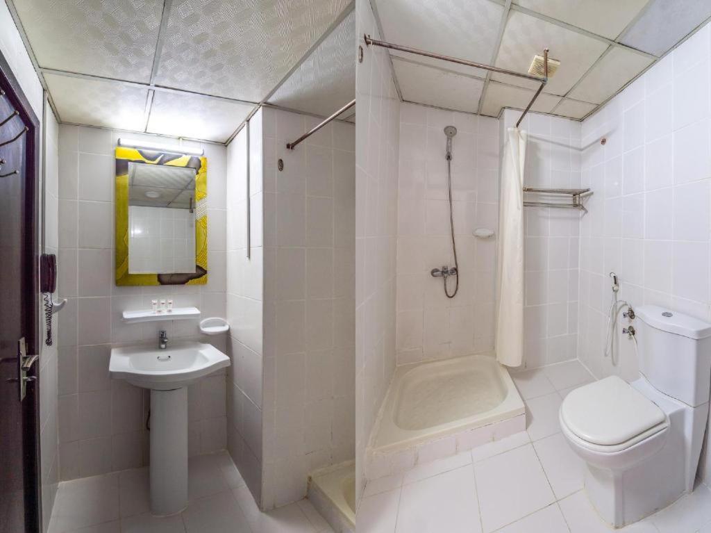 een witte badkamer met een toilet en een wastafel bij Mermaid Beach Hotel LLC in Ajman 