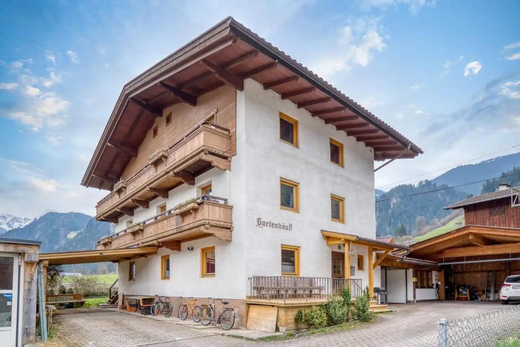 een groot wit gebouw met een balkon bij Adventure Holiday Hub: Gartenhäusl in Mayrhofen