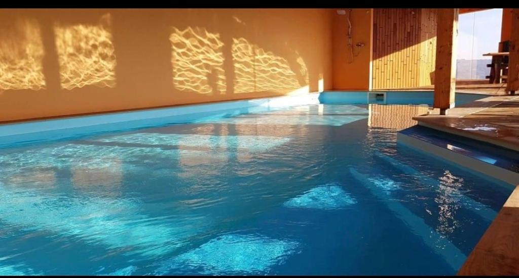 a swimming pool with blue water in a building at Country House Zemljanka in Šentrupert