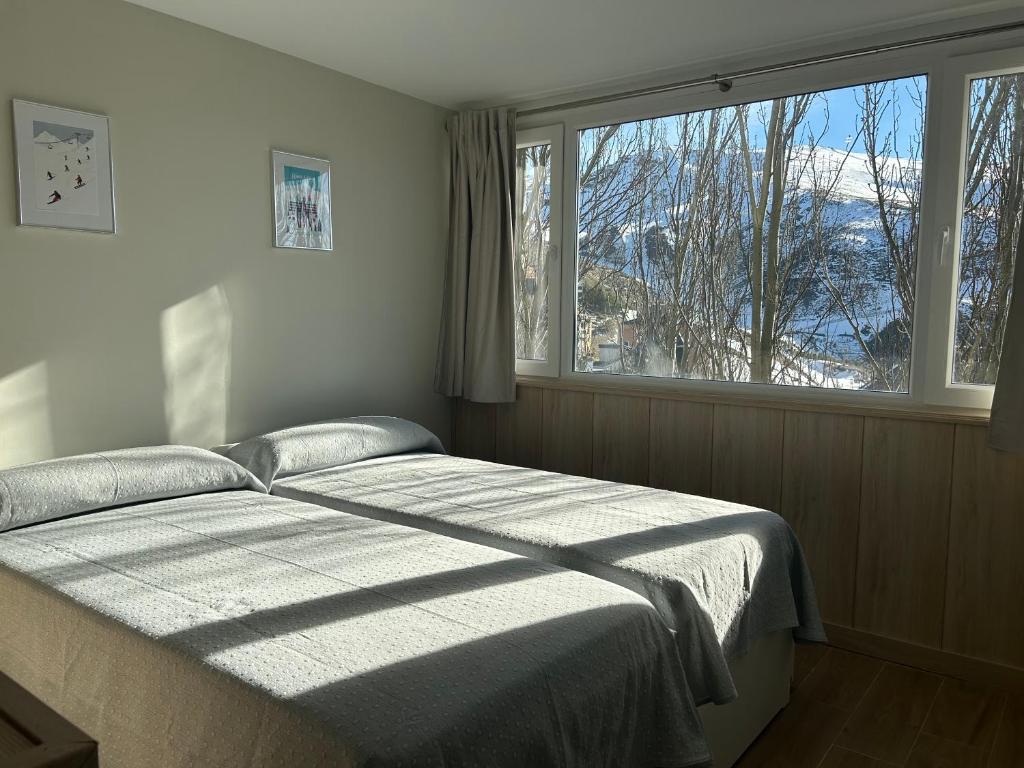 a bedroom with a bed and a large window at Primavera Premium Sierra Nevada 2 in Sierra Nevada