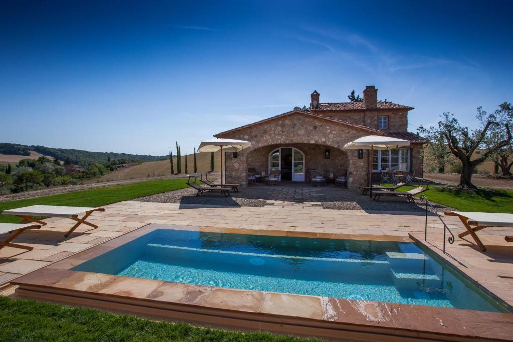 a house with a swimming pool in front of a building at Villa La Salina in Bibbona