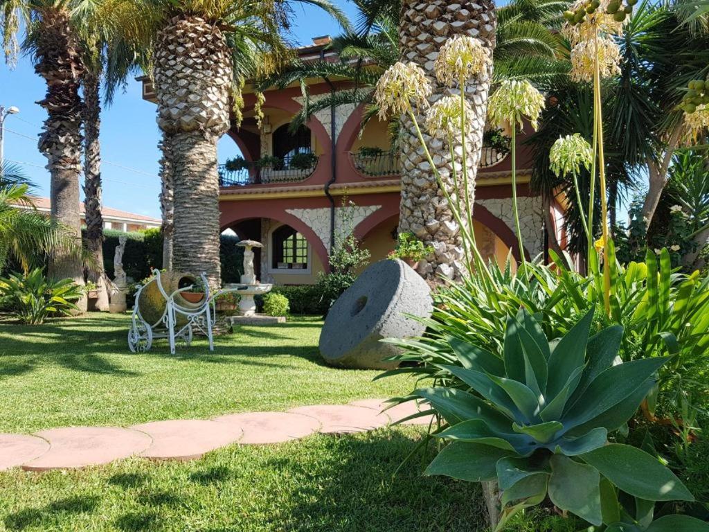 una casa con palmeras en el patio en Villa del Papiro Charme Apartments en Avola