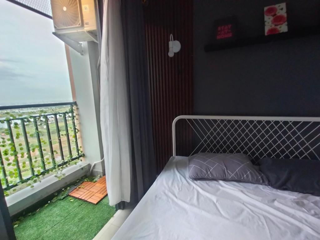 a bedroom with a bed and a window with a view at Studio Healing at Sayana Apartemen Harapan Indah Bekasi 