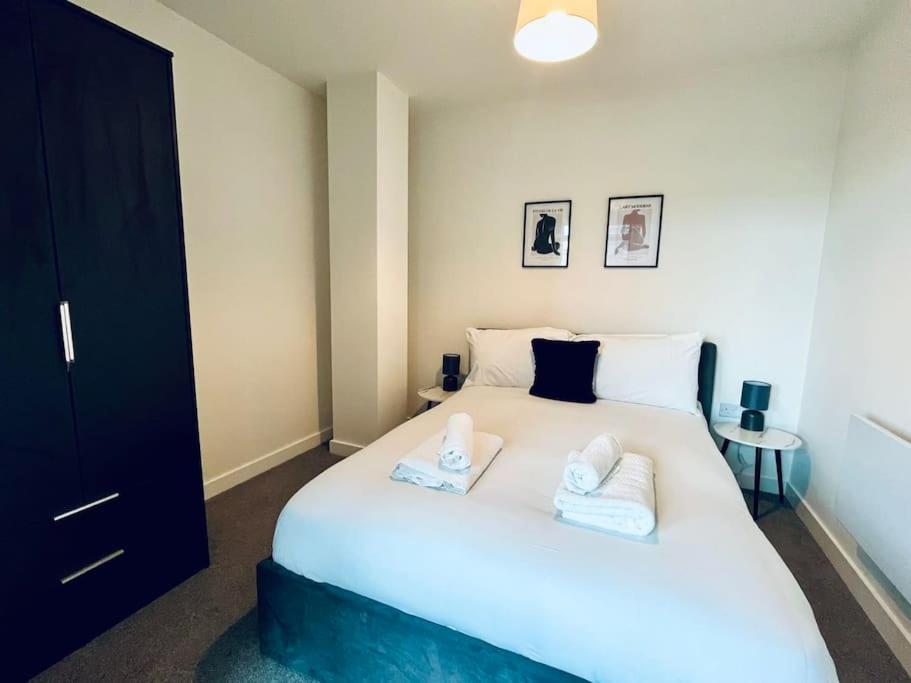 a bedroom with a large white bed with two pillows at Old Trafford Getaway: 1 bed apartment in Manchester