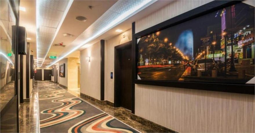 um corredor com uma grande televisão de ecrã plano na parede em فندق الراحة السويسرية em Jidá