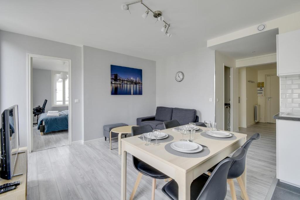 a dining room and living room with a table and chairs at Chic and spacious apart with parking in Cergy