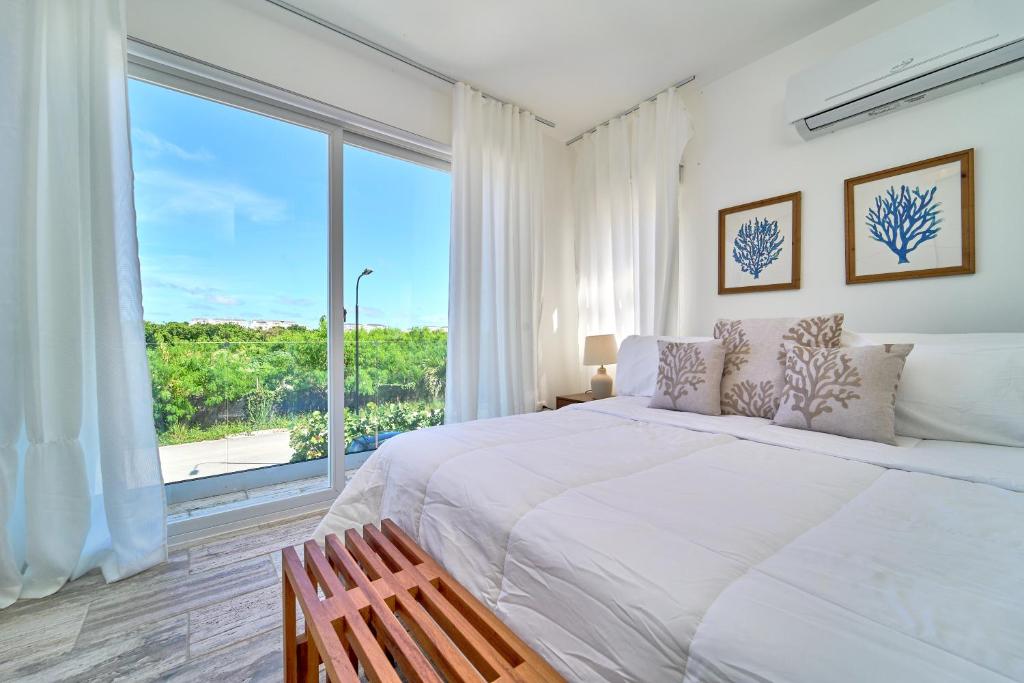 a bedroom with a large bed and a large window at Cana Brava Residences-Comfort Condo in Punta Cana