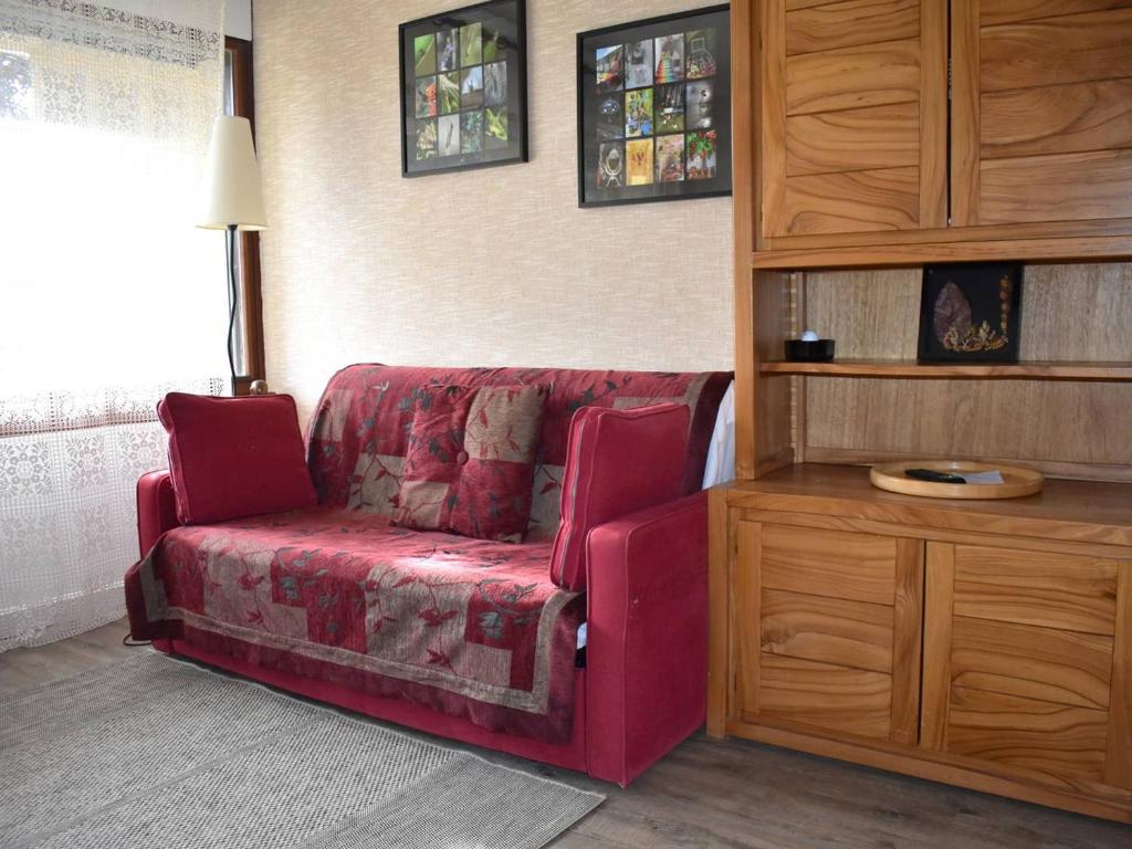 a living room with a red couch and a desk at Studio Font-Romeu-Odeillo-Via, 1 pièce, 4 personnes - FR-1-580-58 in Font-Romeu-Odeillo-Via