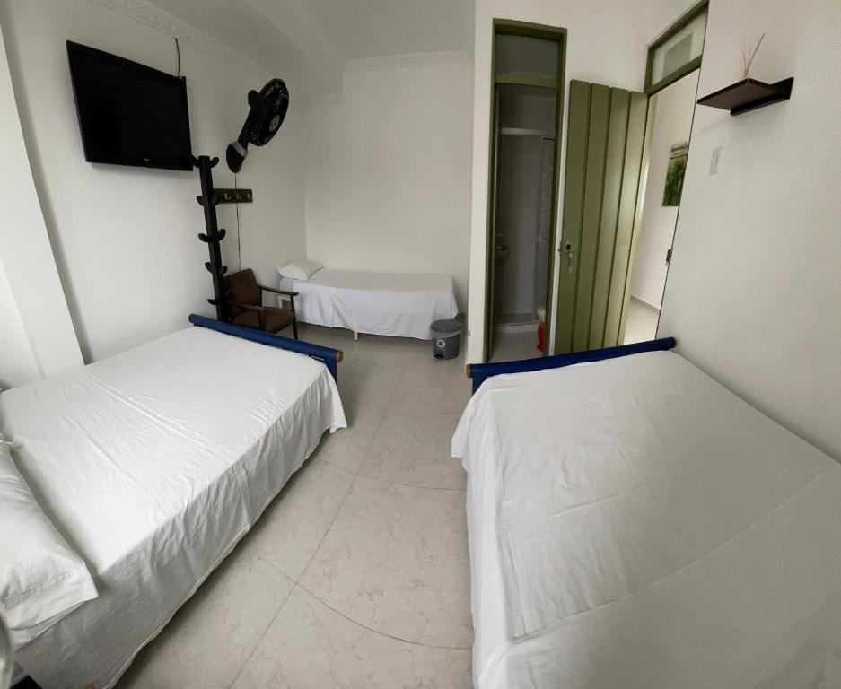 een kamer met 2 bedden en een flatscreen-tv bij Hotel California Tropical in La Tebaida
