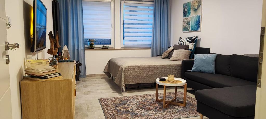 ein Wohnzimmer mit einem Sofa und einem Bett in der Unterkunft Perle im Zentrum von MG / Minto in Mönchengladbach