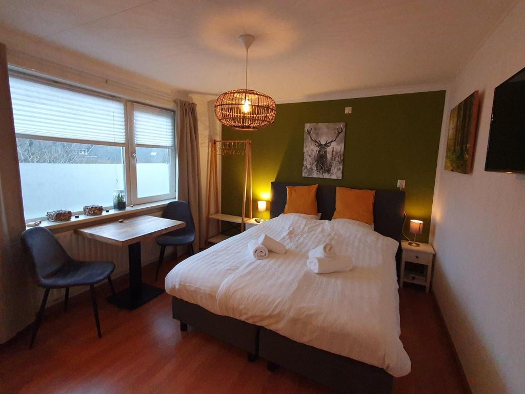 Schlafzimmer mit einem Bett, einem Schreibtisch und einem Fenster in der Unterkunft Sleep Well Ness Domburg in Domburg