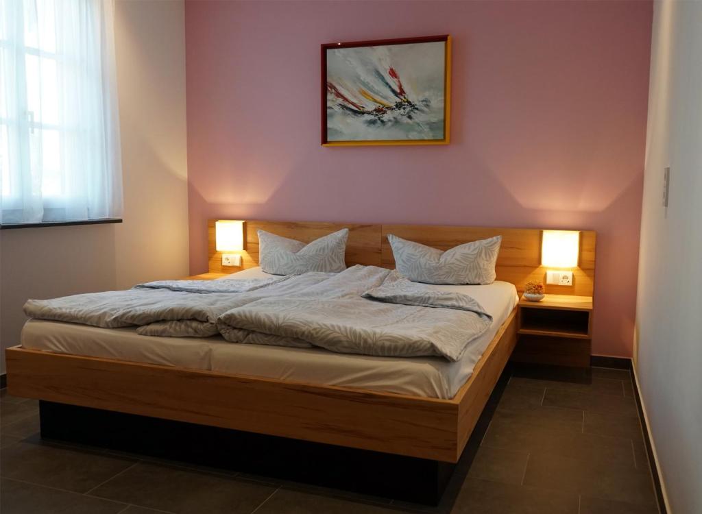 Hotel - Ristorante La Grotta في شباير: غرفة نوم بسرير مع مصباحين وصورة على الحائط
