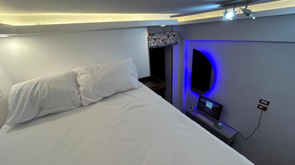 um quarto com uma cama branca e uma luz azul em Unique studio em Aswan