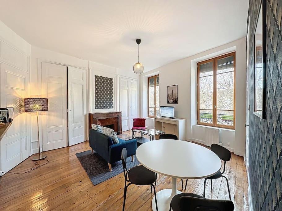 een woonkamer met een tafel en stoelen bij Cosy Appartement, Vaise Salengro 2 in Lyon