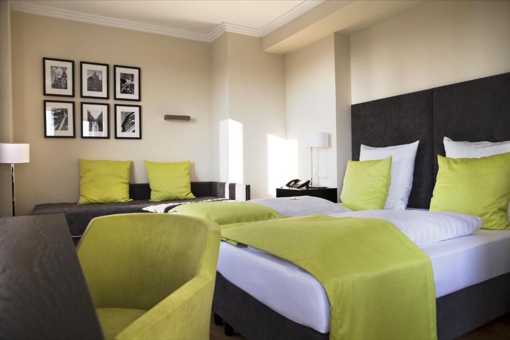 two beds in a hotel room with green cushions at Hotel Hamburger Hof in Frankfurt/Main