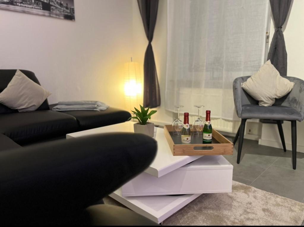 - un salon avec un canapé et une table avec des verres à vin dans l'établissement G&G Homely Apartment Horhausen Westerwald, à Bendorf