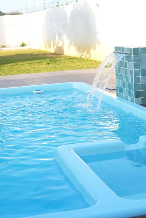 una fuente de agua en una piscina en un patio en Villa Romeu en Fortim