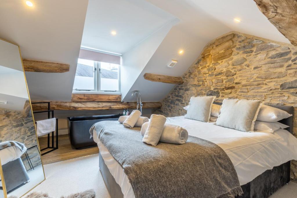 a bedroom with a large bed and a stone wall at 3 Beck Head Kirkby Lonsdale in Kirkby Lonsdale