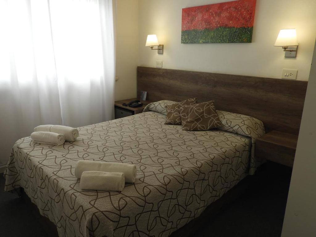 a bedroom with a bed with two pillows on it at HOTEL ROMA DE TANDIL in Tandil