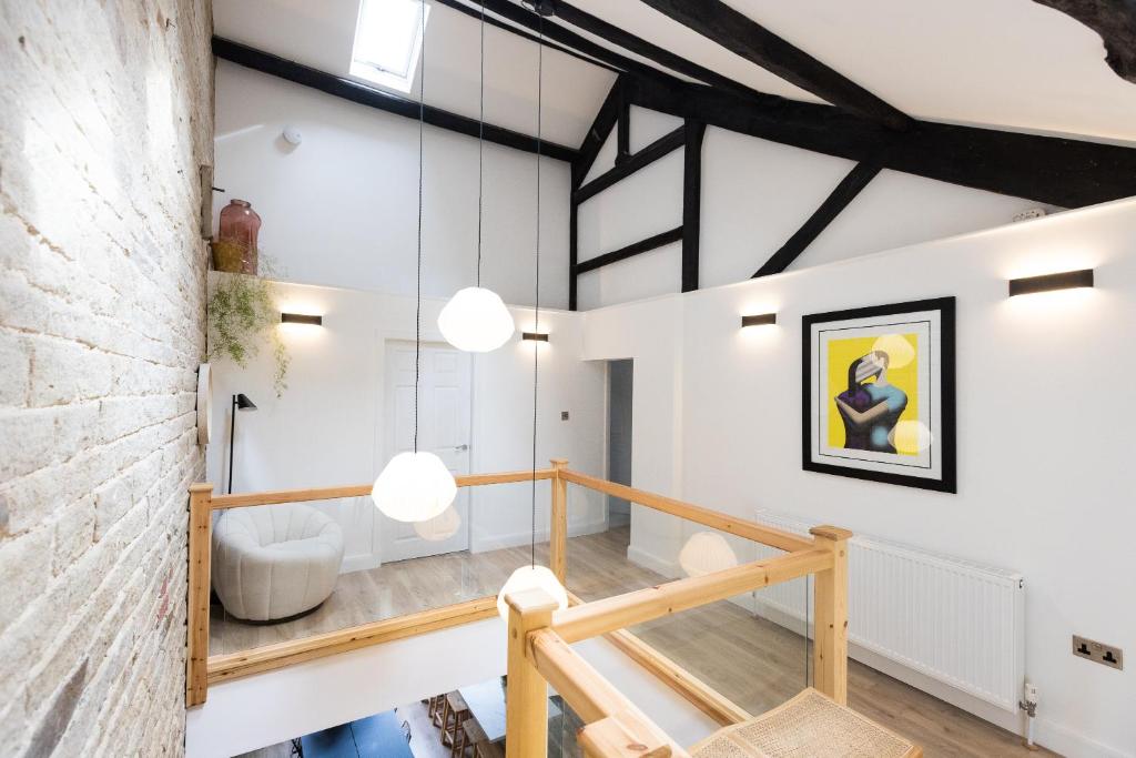 a loft conversion with white walls and a wooden staircase at The Wagon Shed in Sowerby Bridge