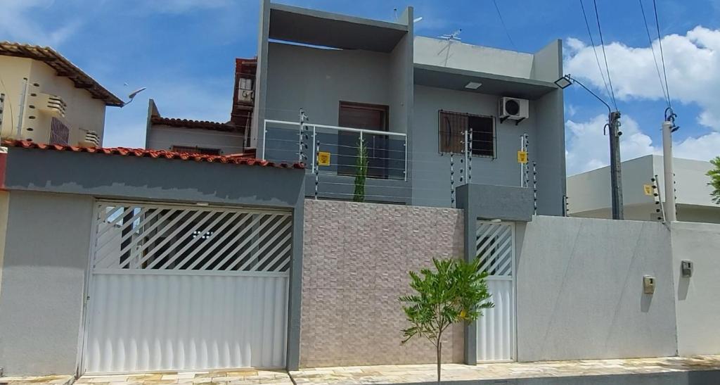 a house with two garage doors and a fence at Casa em Tamandaré in Tamandaré
