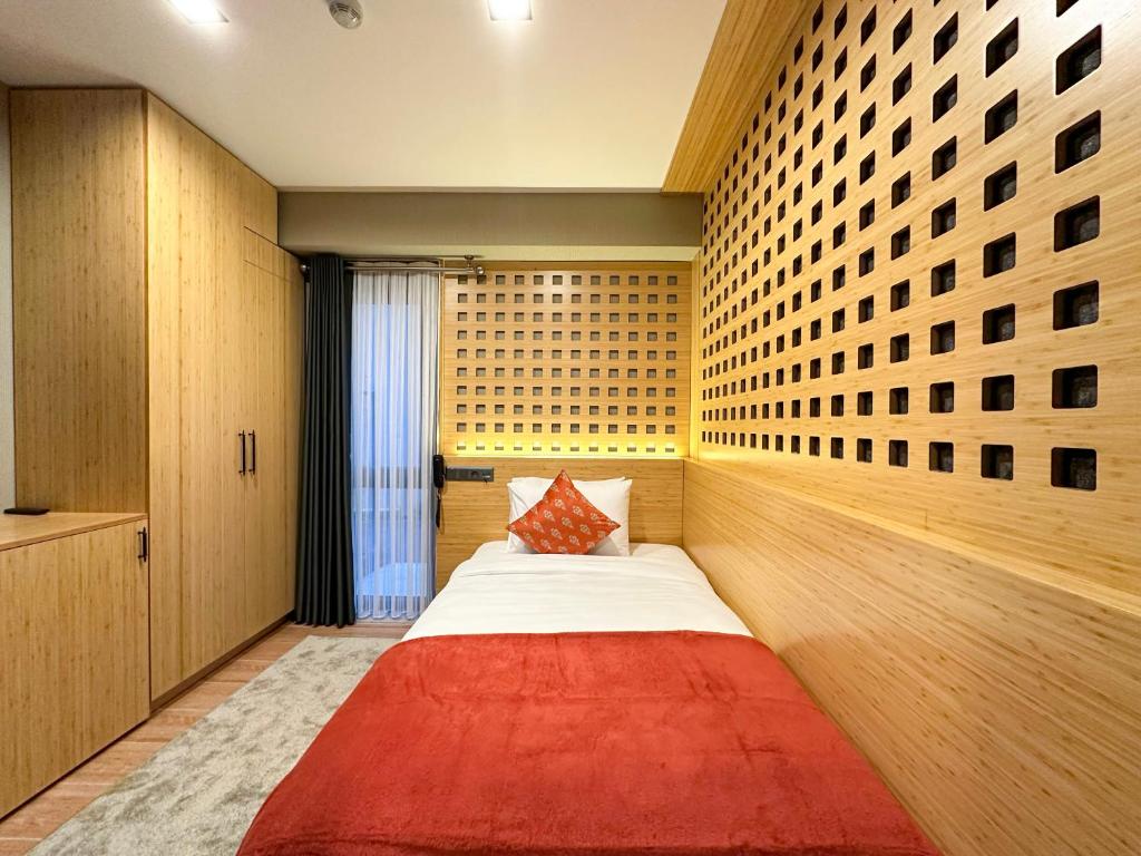 a bedroom with a bed with a red blanket at Mihman Hotel in Tuzla
