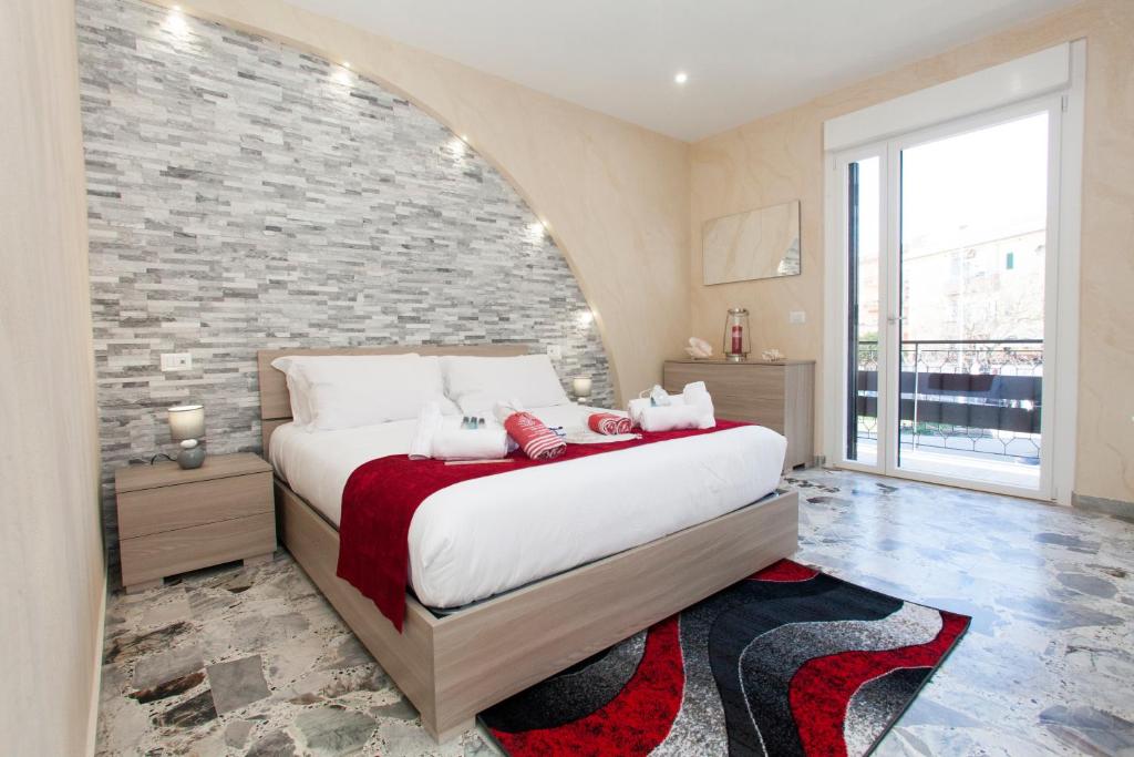 a bedroom with a large bed and a brick wall at Luxury house Il tramonto in Anzio