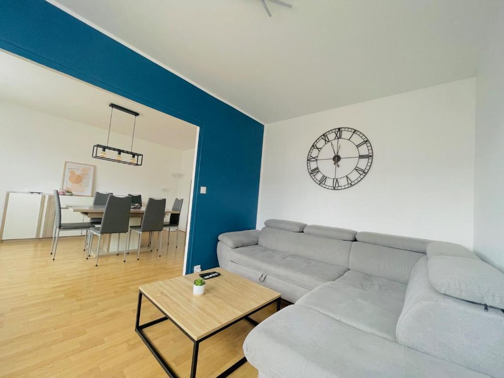 uma sala de estar com um sofá e uma mesa em Grand 2 chambres & parking em Besançon