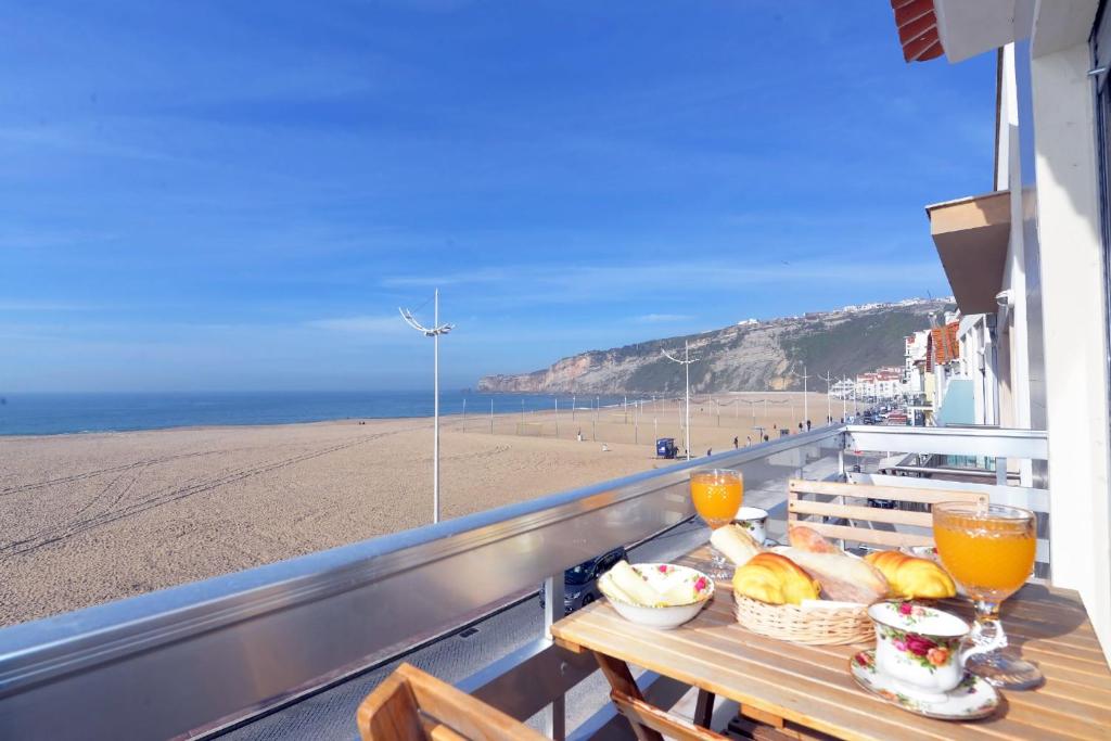 uma varanda com uma mesa e vista para a praia em Mar&Sol em Nazaré