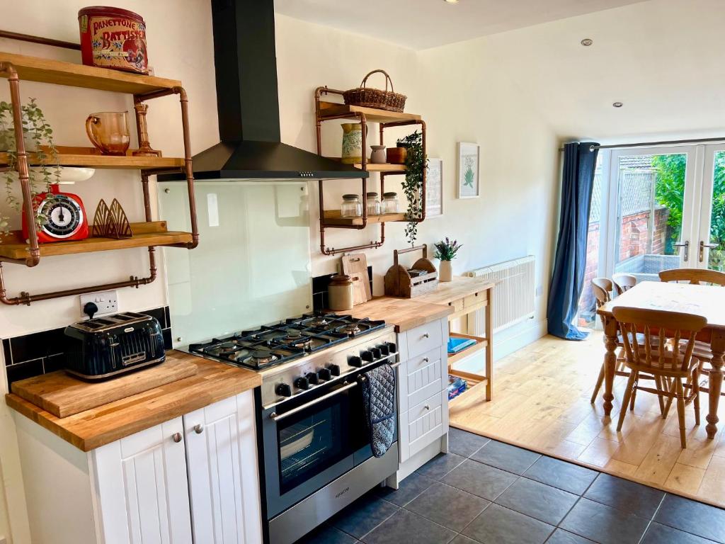 a kitchen with a stove and a table in it at Spacious Victorian townhouse with Cathedral views in Lincoln