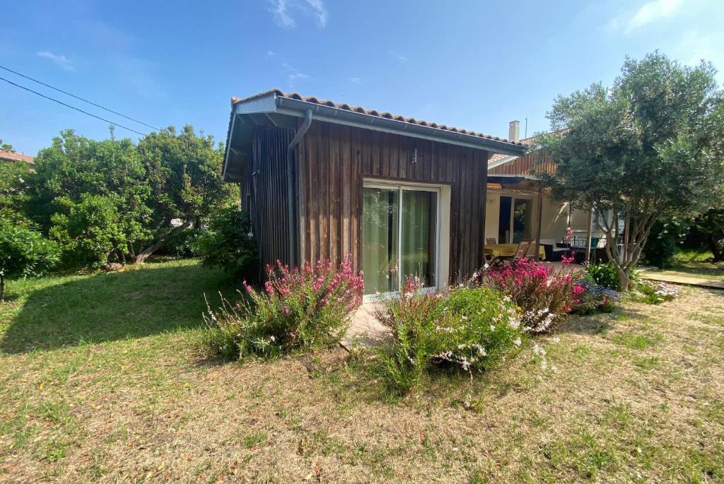 une petite maison dans une cour fleurie dans l'établissement VILLA DES ORTOLANS au CAP FERRET, à Cap-Ferret