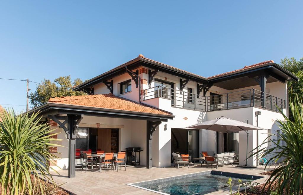 une maison avec une piscine devant dans l'établissement VILLA FABIENNE en plein centre ville avec piscine chauffée pour 6 personne, à Andernos-les-Bains