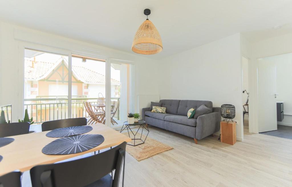 a living room with a table and a couch at APPARTEMENT Des Verdiers in Andernos-les-Bains