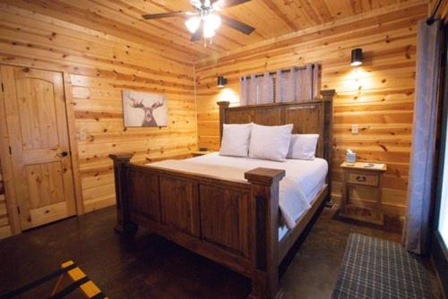 um quarto com uma cama num chalé de madeira em 4BR/3Bth family cabin with a hot tub, sleeps 14 em Broken Bow