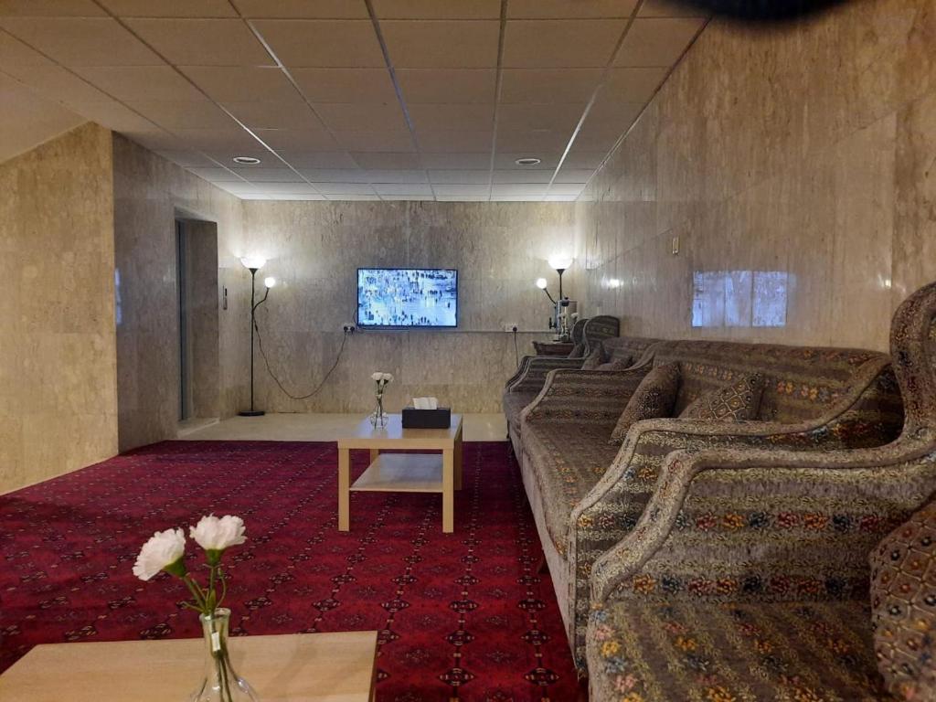 een kamer met banken, een tafel en een tv bij الساعه 60 الفندقيه in Dammam