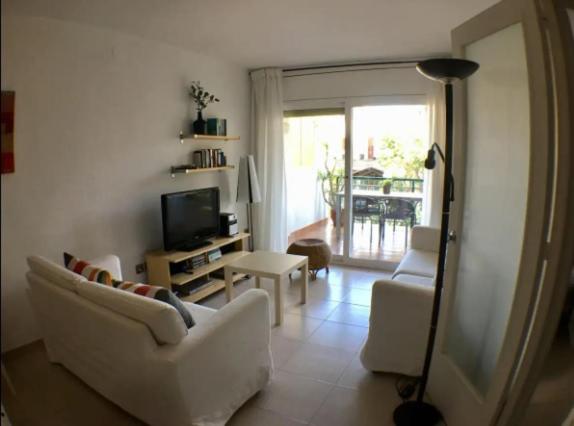 ein Wohnzimmer mit einem weißen Sofa und einem TV in der Unterkunft Apartamento en Vilanova in Vilanova i la Geltrú