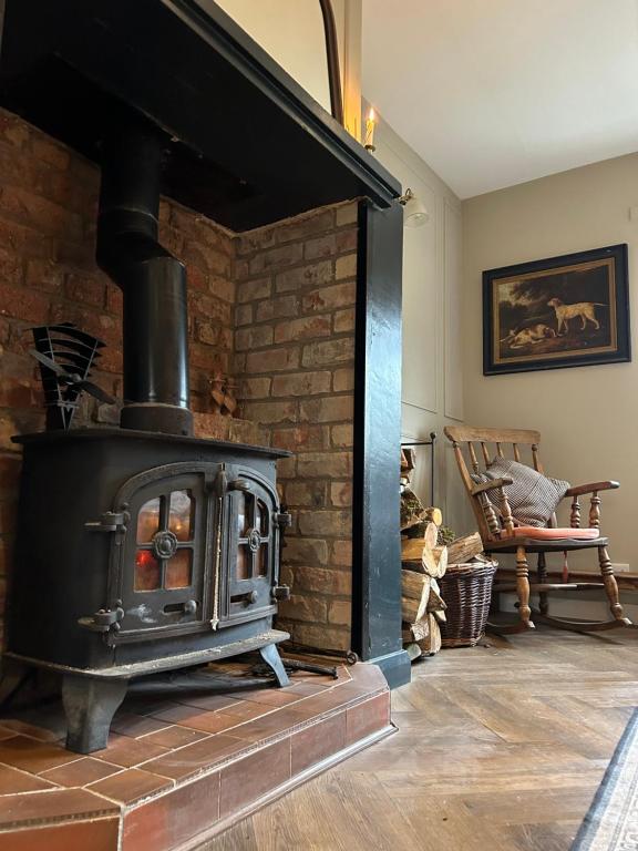 chimenea de ladrillo con estufa en la habitación en Favour Royal Cottage - dog friendly forest escape en Derrygorry