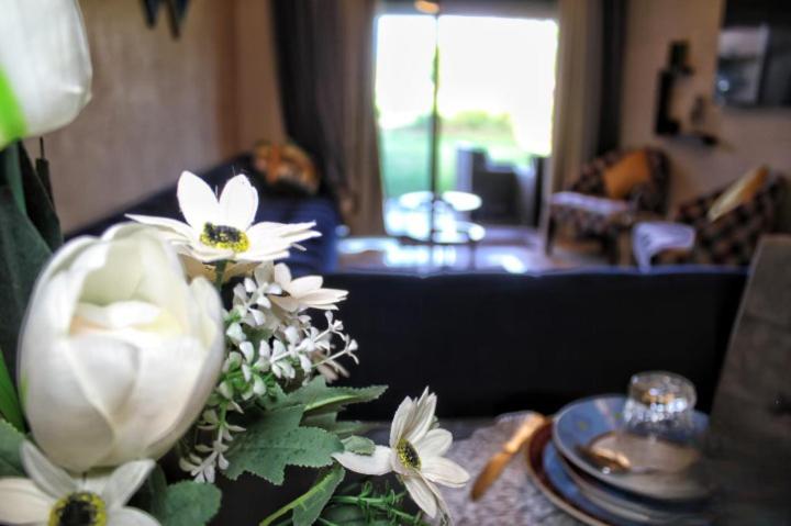 une table avec un vase de fleurs blanches sur elle dans l'établissement Appartement de Luxe Prestigia, à Marrakech