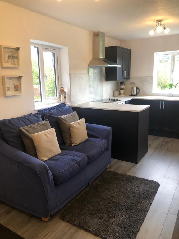 un soggiorno con divano blu in cucina di Delightful Artistic Granite Barn in Rural Hamlet a Launceston