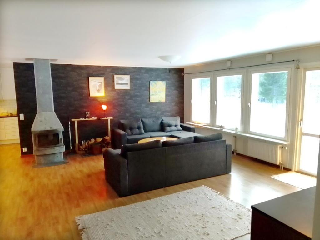 sala de estar con sofá y chimenea en Havsnära villa en Nordmaling