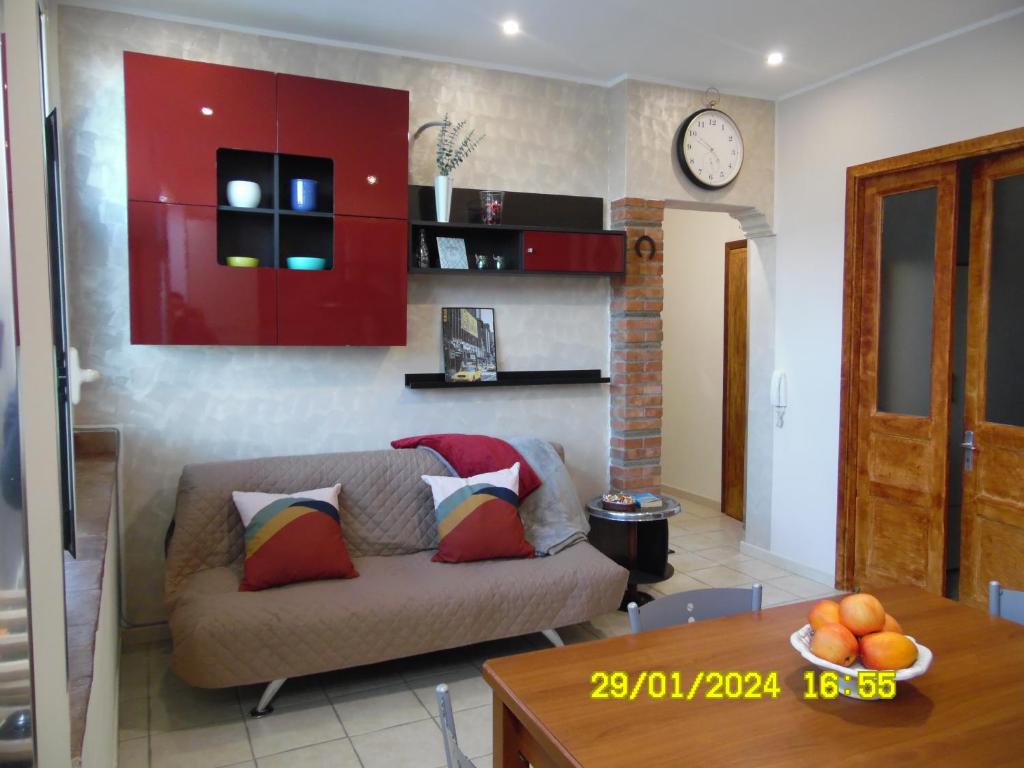ein Wohnzimmer mit einem Sofa und einer Uhr an der Wand in der Unterkunft La Casa di Giuditta - B&B Casa Vacanze - Ramacca in Ramacca