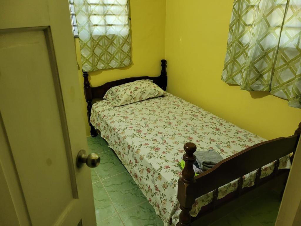 a small bedroom with a bed in a room at Tim's & Mag's Home Stay in Roseau