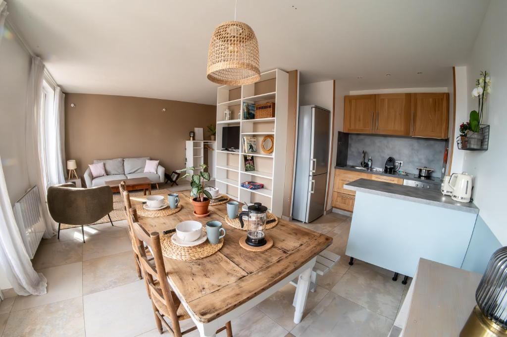 een keuken en een woonkamer met een houten tafel bij Les 3 Monts - vue panoramique sur les montagnes in Annecy