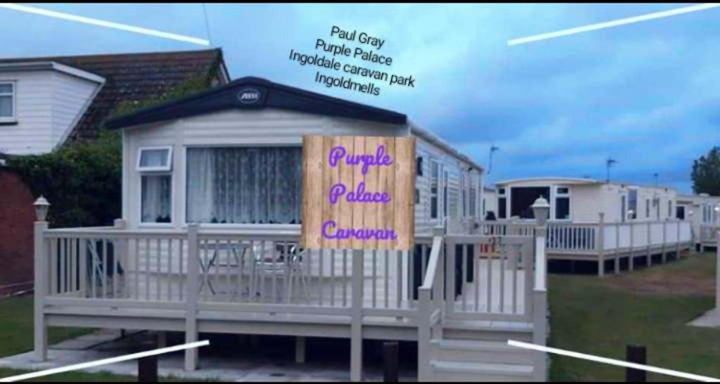 a small white house with a sign on it at Purple Palace 3-Bed Caravan Ingoldmells in Ingoldmells