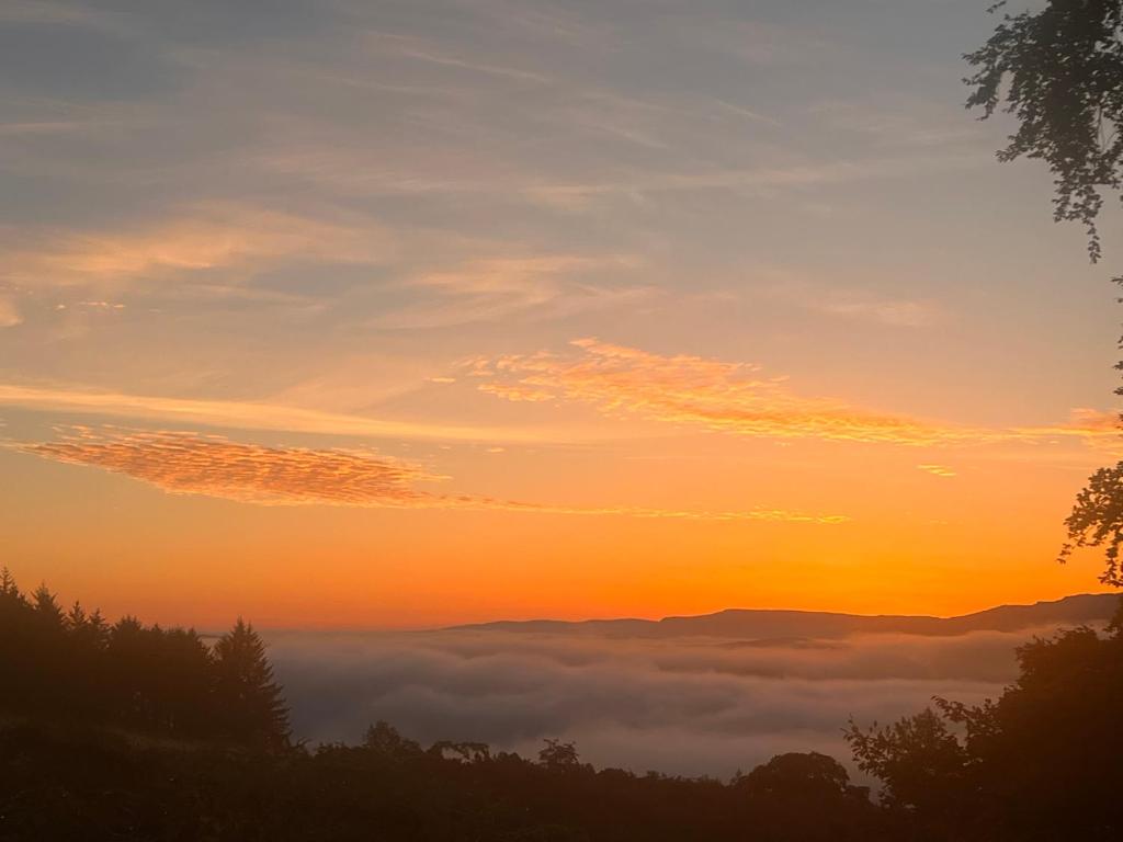 una vista de la puesta de sol con una capa de nubes en Stoneymollan over Loch Lomond en Balloch