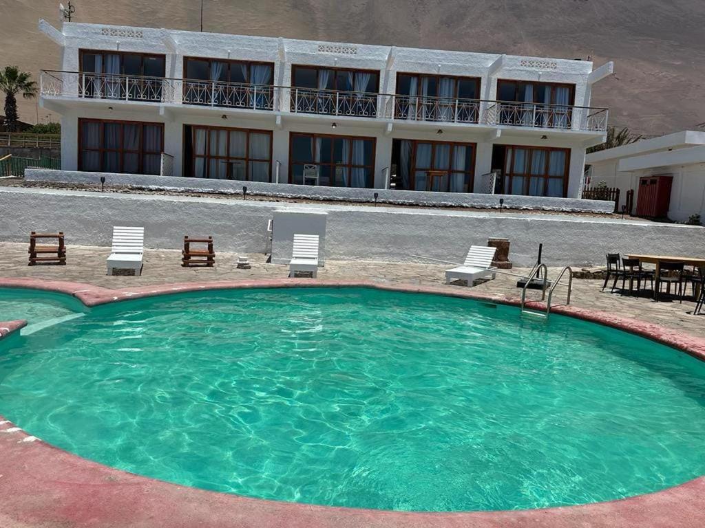 a large swimming pool in front of a building at Hotel Josefina in Alto Hospicio