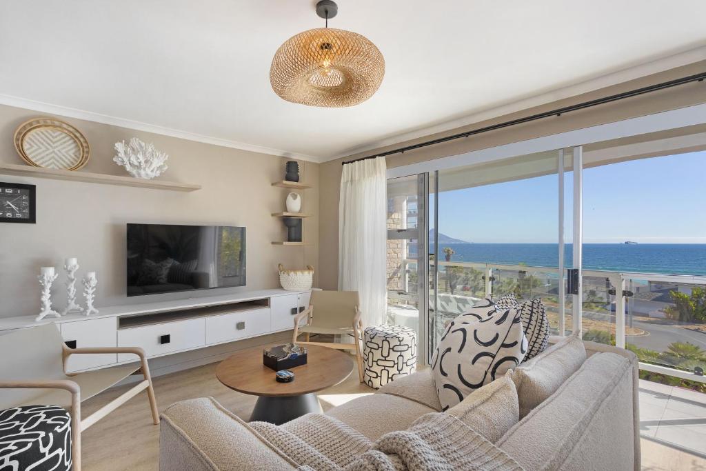 a living room with a couch and a tv at Coral Island 204 in Bloubergstrand