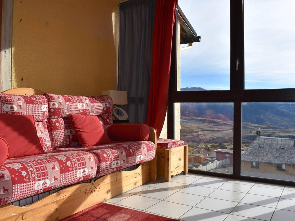 a living room with a couch and a large window at Studio Font-Romeu-Odeillo-Via, 1 pièce, 4 personnes - FR-1-580-86 in Font-Romeu-Odeillo-Via