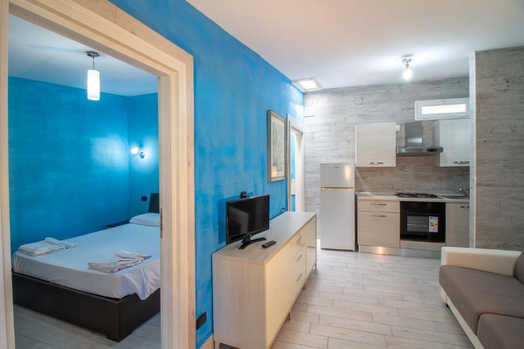een blauwe kamer met een bed en een keuken bij Il Posto in Pulsano